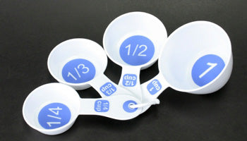 A set of white measuring cups with bold white letters on a blue background