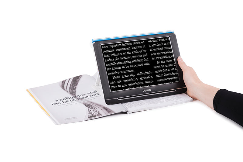 The Compact 10 has black trim around the edges and a blue line across the the top. It's being used to magnify text from a magazine.